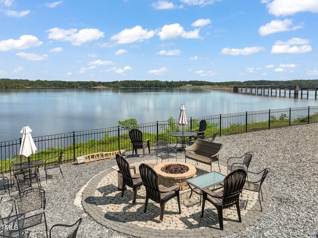 view of patio with an outdoor fire pit and a water view