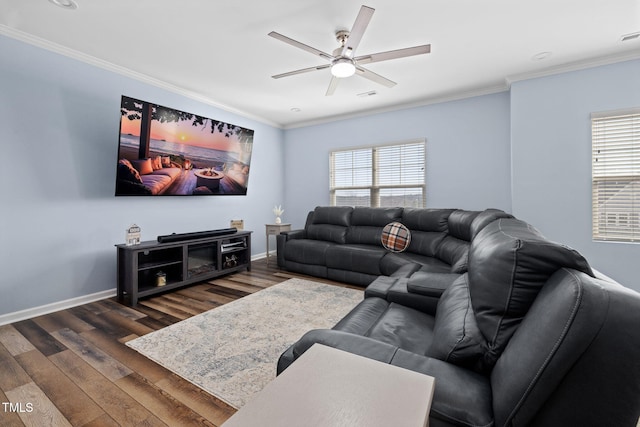 living area featuring dark wood-type flooring, ornamental molding, baseboards, and a ceiling fan