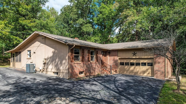 view of front of property with a garage and central AC