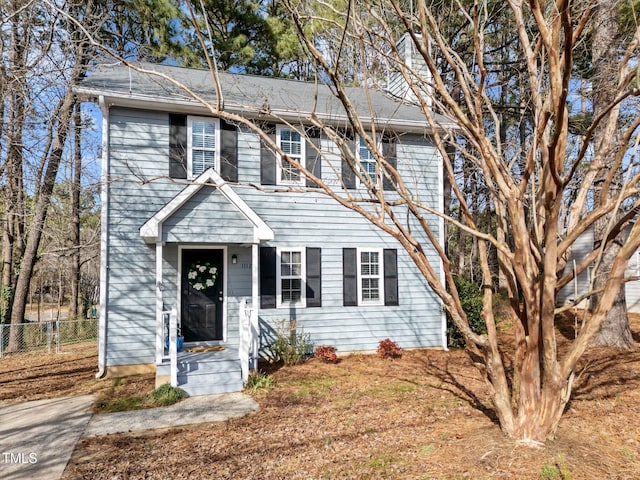 colonial-style house with fence