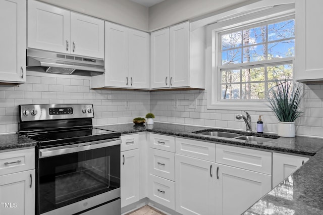 kitchen with stainless steel range with electric cooktop, a sink, white cabinetry, dark stone countertops, and under cabinet range hood