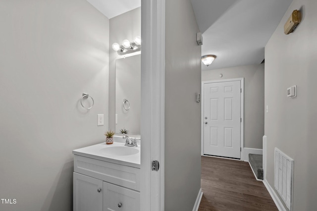 bathroom featuring baseboards, visible vents, wood finished floors, and vanity