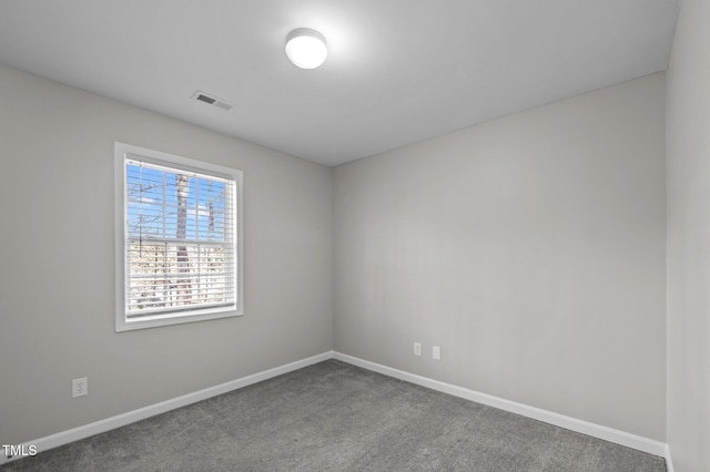 empty room with baseboards, visible vents, and carpet flooring