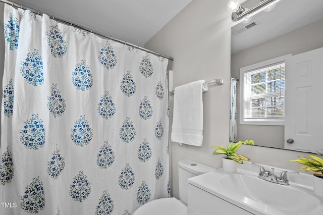 bathroom featuring toilet, a shower with curtain, visible vents, and vanity