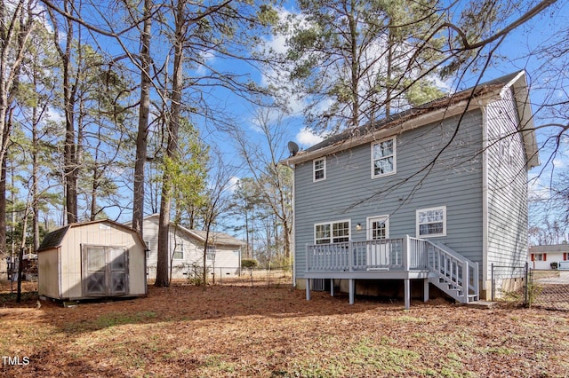 back of property featuring fence, a deck, a shed, an outdoor structure, and stairs