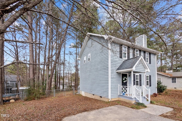 view of front of house featuring roof with shingles, crawl space, a chimney, and fence