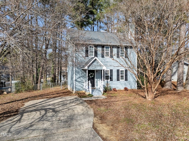 colonial home featuring fence