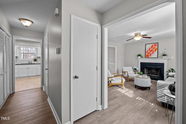 hall with light wood-style floors and baseboards