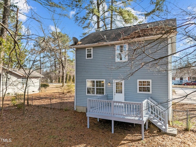 rear view of property with a wooden deck and fence