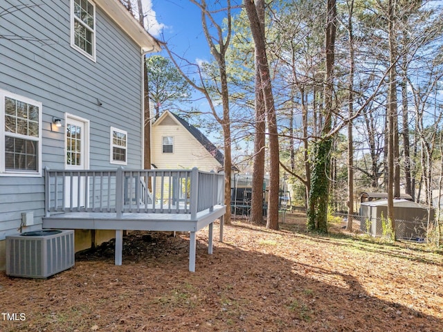 view of yard with central AC, fence, and a deck