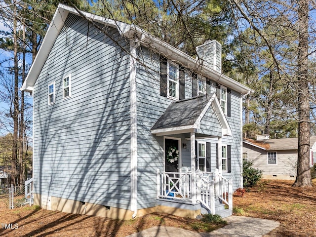 view of front of property with crawl space and a chimney