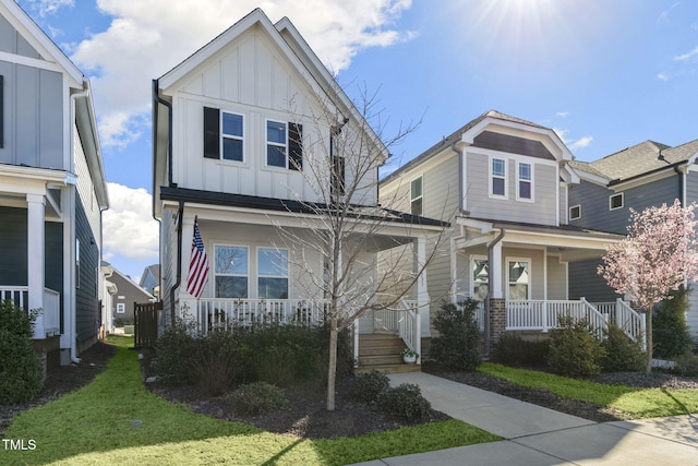 view of front of house with a porch, board and batten siding, and a front yard