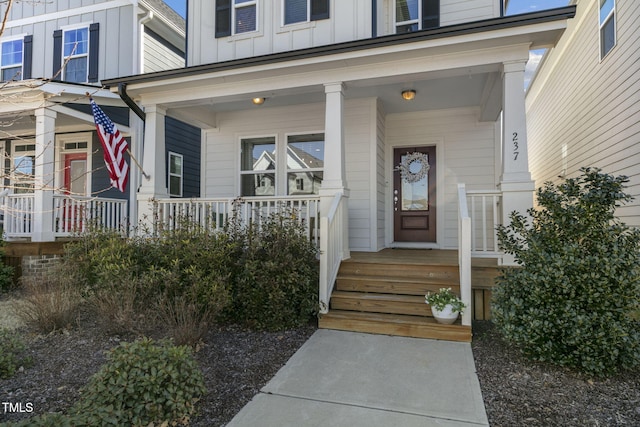 view of exterior entry featuring board and batten siding and covered porch