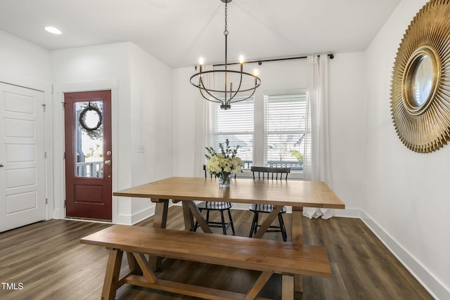 dining area featuring dark wood-style floors, baseboards, and an inviting chandelier