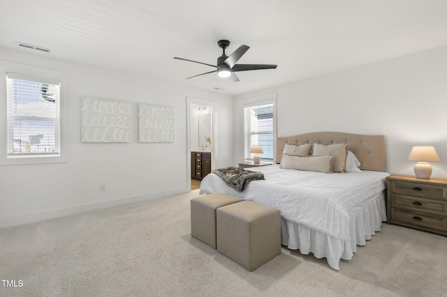 bedroom with light carpet, a ceiling fan, visible vents, baseboards, and ensuite bath