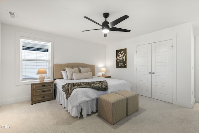 carpeted bedroom with a ceiling fan, baseboards, visible vents, and a closet