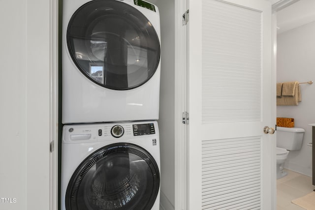 clothes washing area featuring stacked washing maching and dryer and laundry area