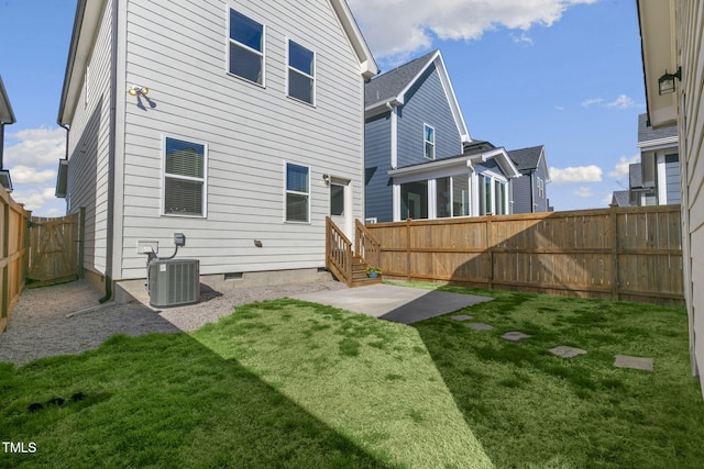 back of property with central AC unit, a fenced backyard, crawl space, a lawn, and a patio area