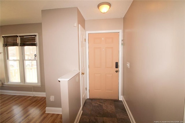 doorway to outside with wood finished floors and baseboards