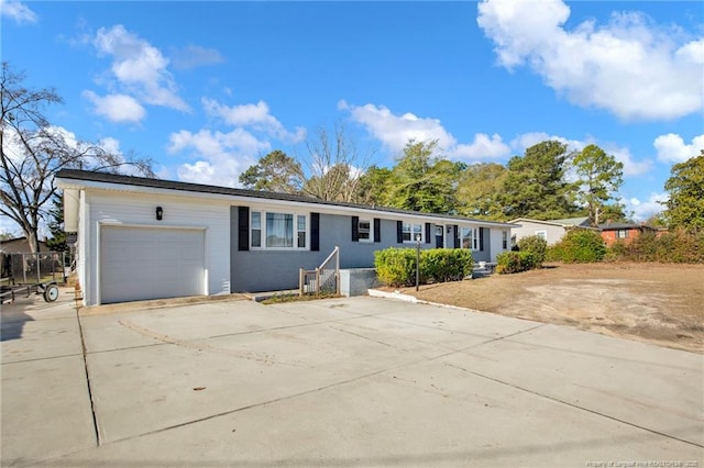 ranch-style home with concrete driveway and an attached garage