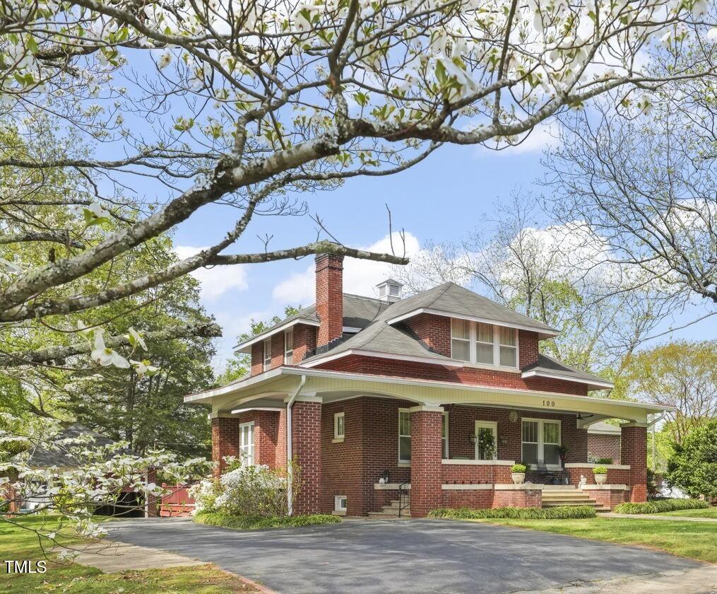 100 Eight St, Clarksville, VA 23927 - view of front of house with brick siding, a chimney, and covered porch