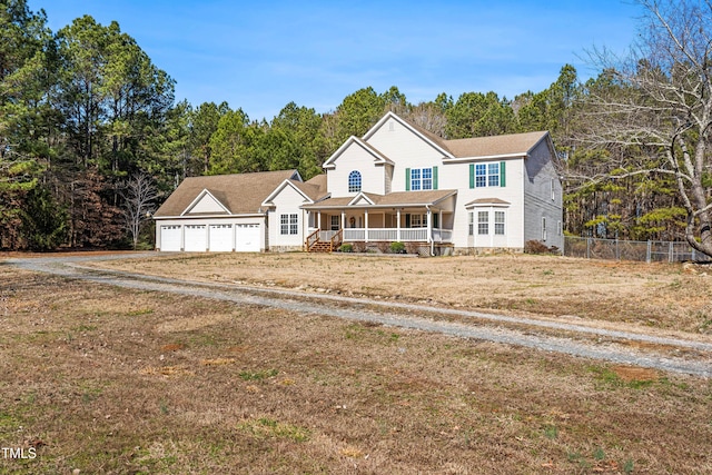 view of front of property with a garage, a front yard, and a porch