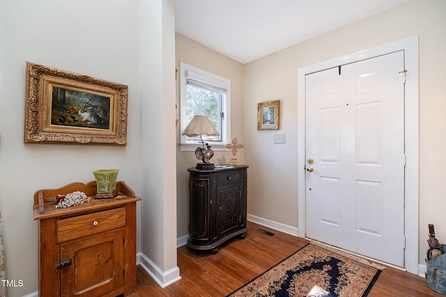 entrance foyer featuring dark wood-style floors, visible vents, and baseboards