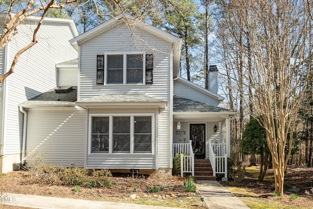 traditional home with a porch and a shingled roof