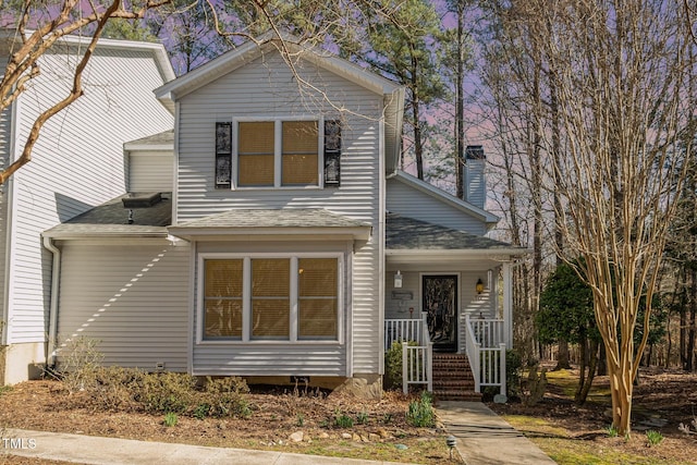 traditional-style house featuring a porch and a shingled roof