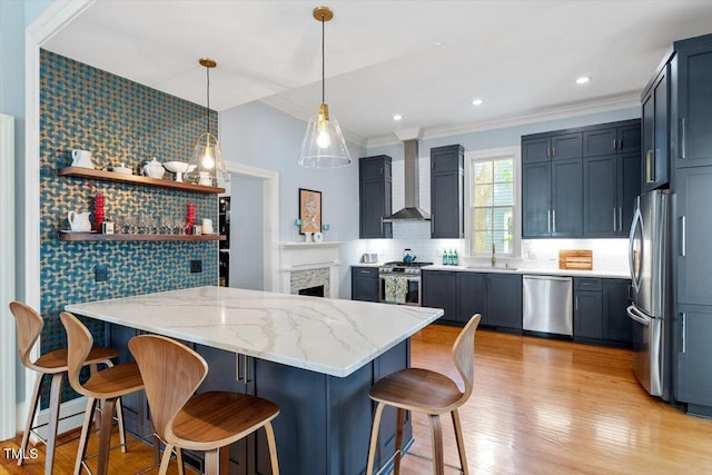 216 N Bloodworth St, Raleigh, NC 27601 - kitchen featuring light stone counters, a sink, wall chimney exhaust hood, stainless steel appliances, and a peninsula