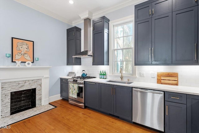 216 N Bloodworth St, Raleigh, NC 27601 - kitchen with crown molding, appliances with stainless steel finishes, a sink, light countertops, and wall chimney exhaust hood