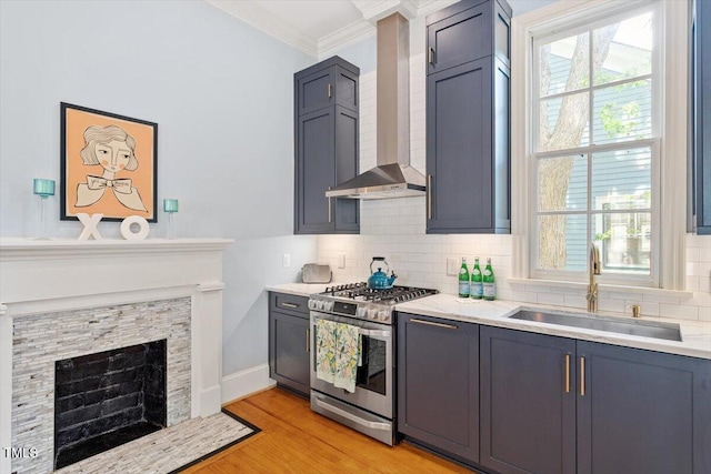 216 N Bloodworth St, Raleigh, NC 27601 - kitchen with crown molding, decorative backsplash, gas range, wall chimney exhaust hood, and a sink