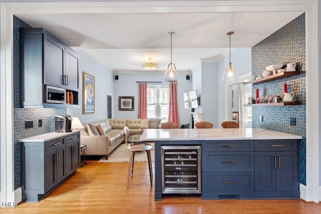 216 N Bloodworth St, Raleigh, NC 27601 - bar featuring beverage cooler, ornamental molding, stainless steel microwave, light wood-type flooring, and pendant lighting