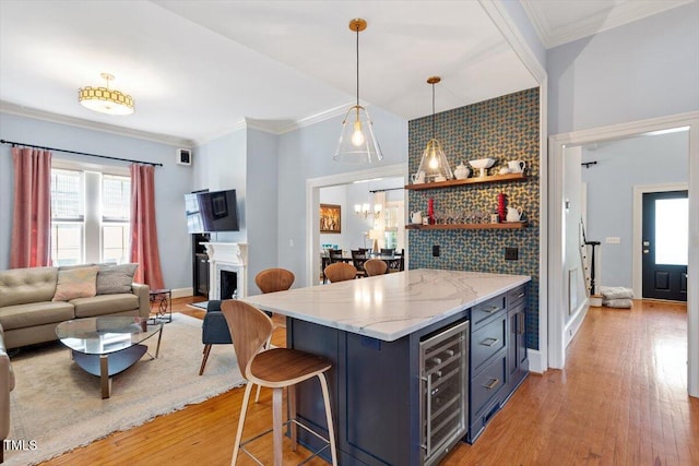216 N Bloodworth St, Raleigh, NC 27601 - kitchen featuring a fireplace, beverage cooler, open floor plan, light wood-style floors, and a breakfast bar