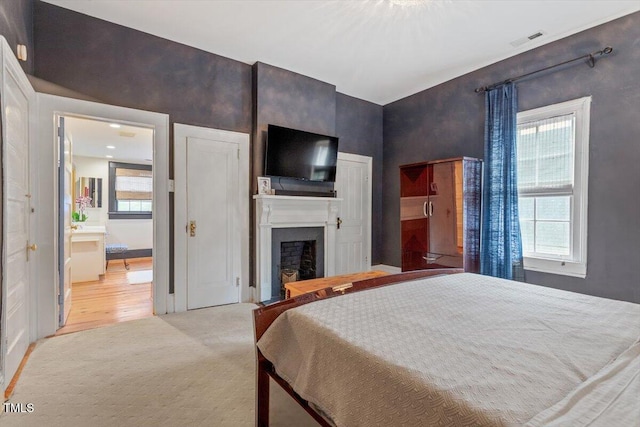 216 N Bloodworth St, Raleigh, NC 27601 - bedroom with light colored carpet, visible vents, and a fireplace
