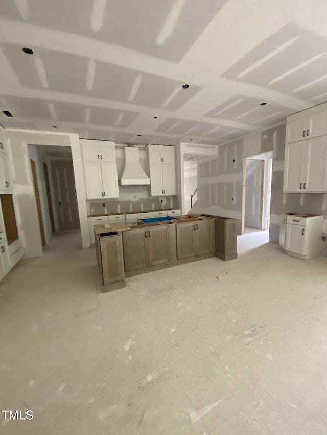 kitchen featuring white cabinets, premium range hood, and a center island
