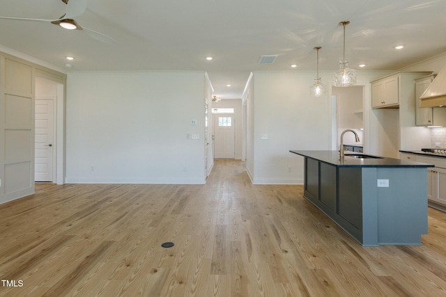 3521 Amelia Grace Dr Lot 67, Fuquay Varina, NC 27526 - kitchen featuring a sink, ornamental molding, dark countertops, cooktop, and a kitchen island with sink