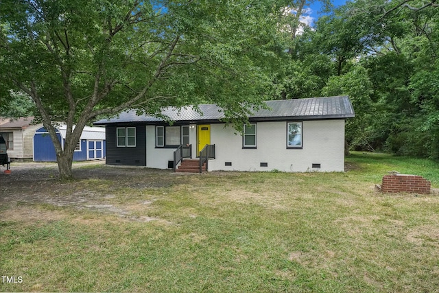 single story home featuring crawl space, brick siding, metal roof, and a front lawn