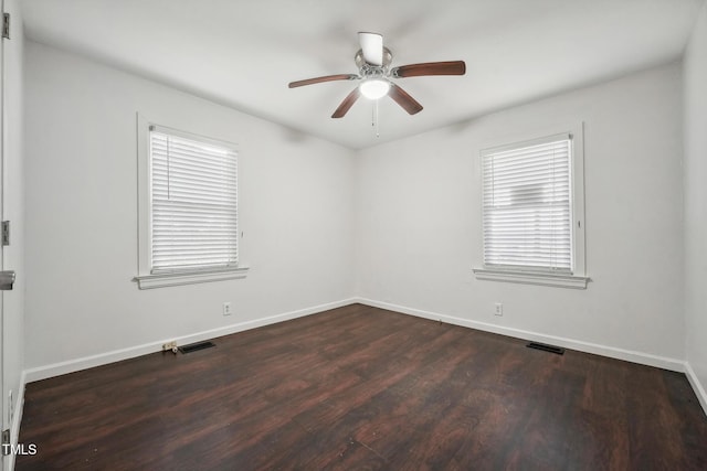 unfurnished room featuring visible vents, baseboards, ceiling fan, and dark wood-style flooring