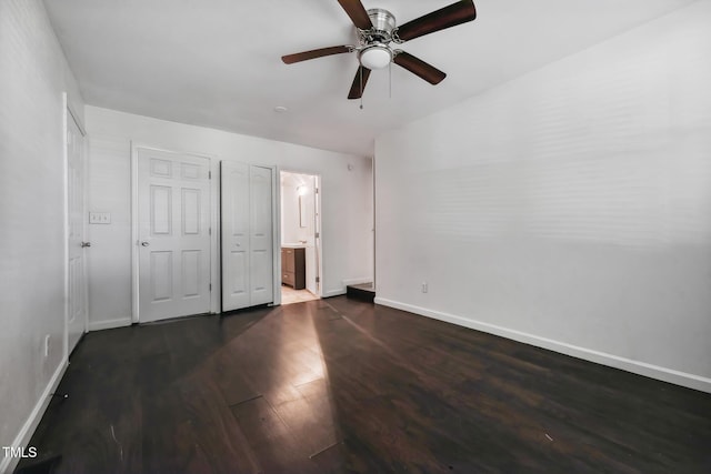 unfurnished bedroom featuring a ceiling fan, dark wood-style flooring, connected bathroom, and baseboards