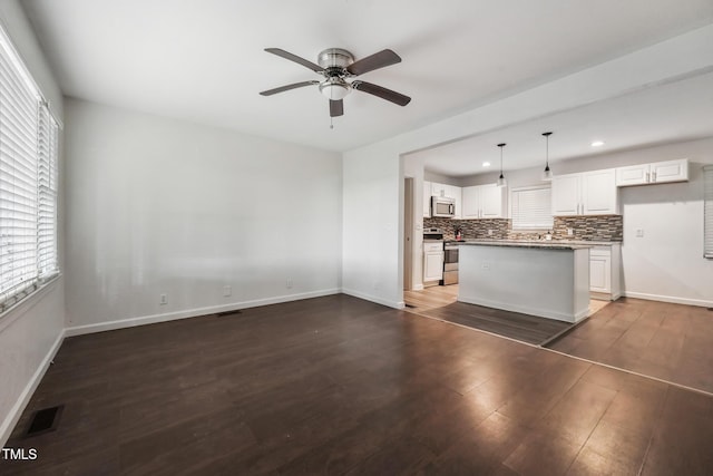 kitchen with tasteful backsplash, visible vents, appliances with stainless steel finishes, white cabinets, and wood finished floors