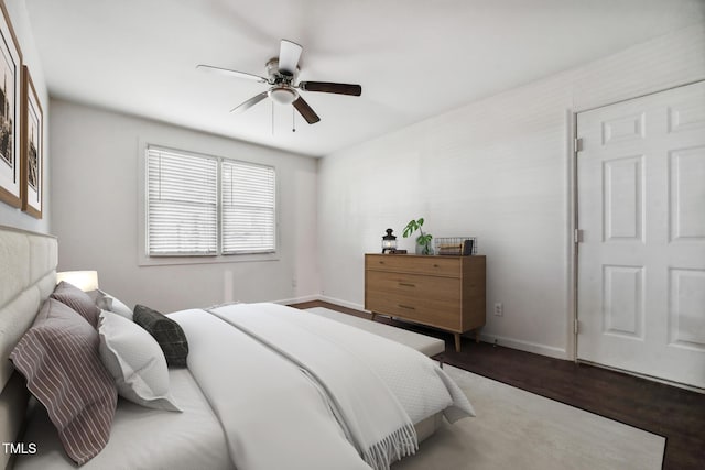 bedroom with ceiling fan, baseboards, and wood finished floors