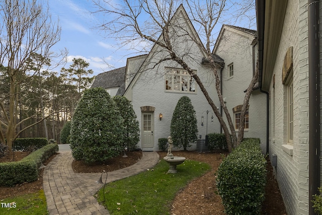 view of front of house with brick siding and central air condition unit