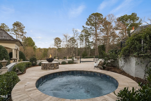 view of swimming pool with an outdoor fire pit, an in ground hot tub, and a patio area