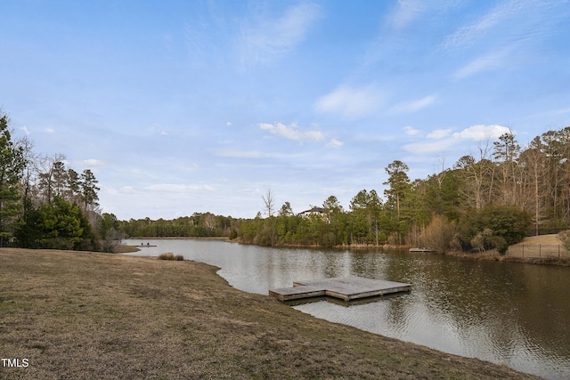 view of dock with a forest view and a water view