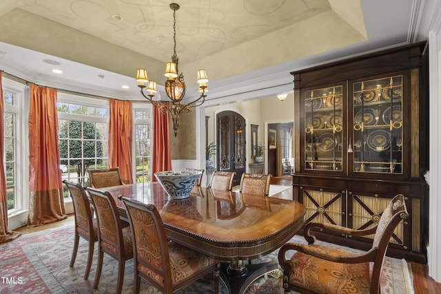 dining area with arched walkways, a notable chandelier, a healthy amount of sunlight, and wood finished floors