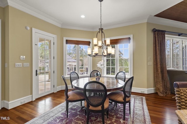 dining space with crown molding, wood finished floors, baseboards, and a chandelier