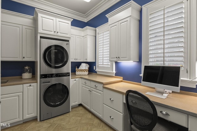 washroom featuring cabinet space, crown molding, and stacked washer / dryer