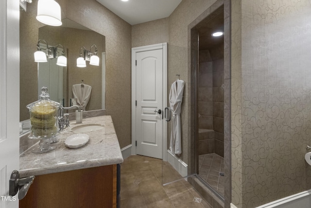 bathroom with vanity, a tile shower, and tile patterned flooring