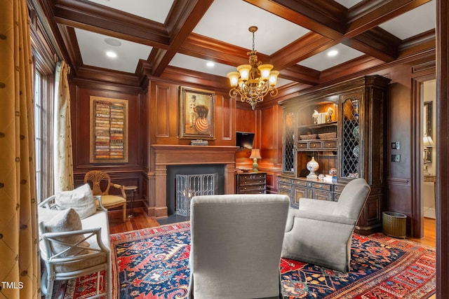 sitting room featuring a fireplace with flush hearth, coffered ceiling, beam ceiling, and a decorative wall